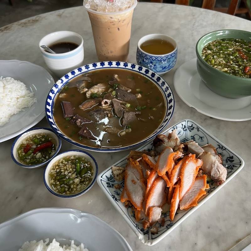 ชุดข้าวสตูบนโต๊ะร้าน มีชามสตู ข้าวสวย หมูแดง และน้ำจิ้ม