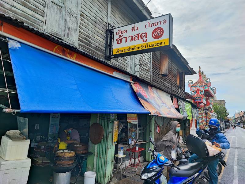 หน้าร้านเกียดฟั่ง ป้ายข้าวสตูและกันสาดสีฟ้าริมถนนนางงาม